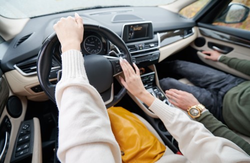 cropped-view-of-women-s-hands-driving-elite-car-1.jpg
